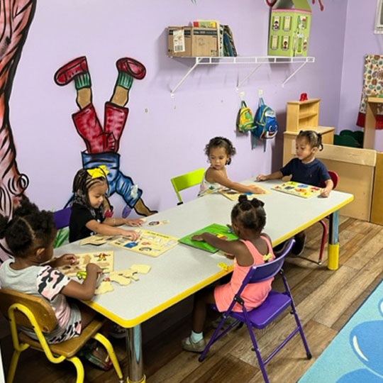 Children learning puzzles at a table.